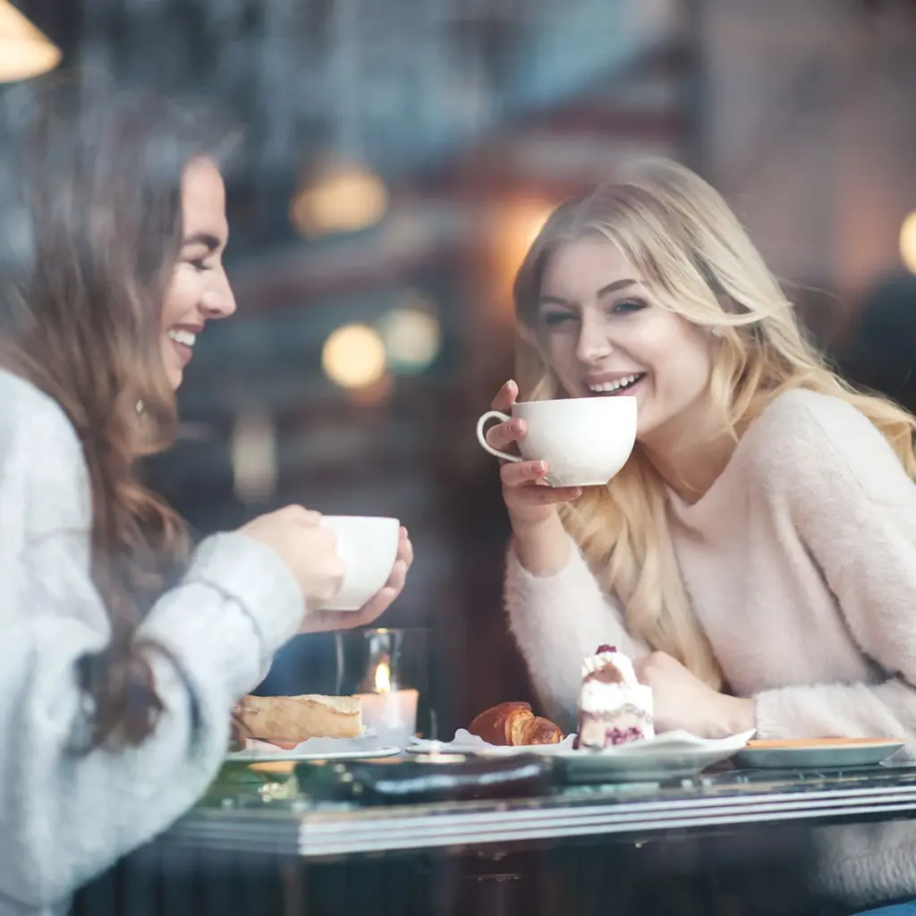 Två personer som sitter på ett café och dricker kaffe tillsammans